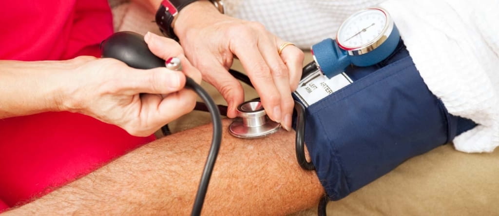 woman taking man's blood pressure