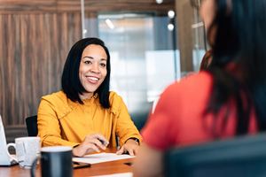 Smiling client signing papers with an advisor