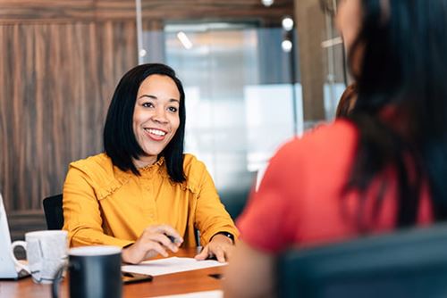 Smiling client signing papers with an advisor