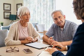 an older couple sitting at a table talking with an advisor