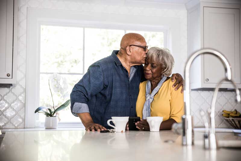 Husband and wife hugging in their kitchen