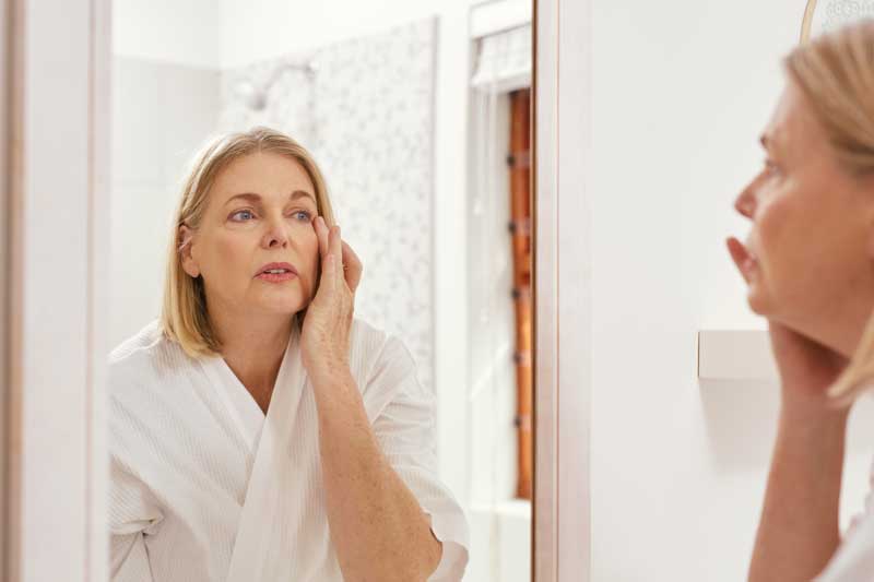 Woman looking at eyes in mirror