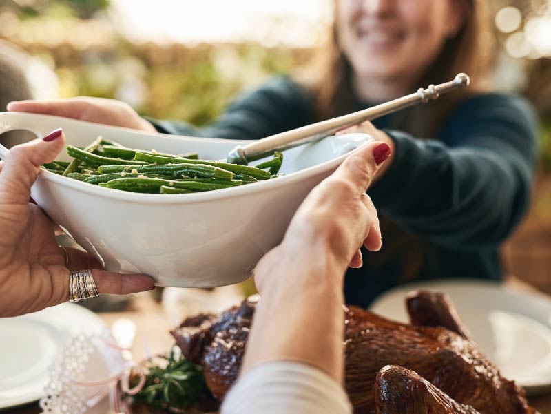 Diners pass bowl of green beans