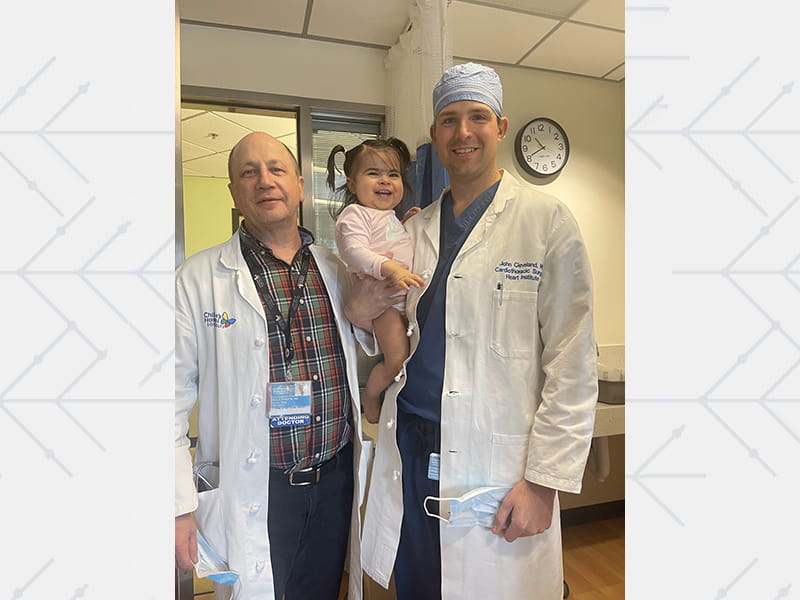 Dr. John David Cleveland holding Aaliyah on the day of her discharge from CHLA, standing next to Dr. Paul Kantor, chief of the hospital's cardiology division