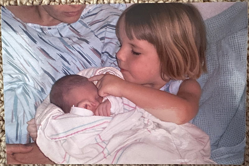 4-year-old Anna holding her baby sister, Ella, at the hospital