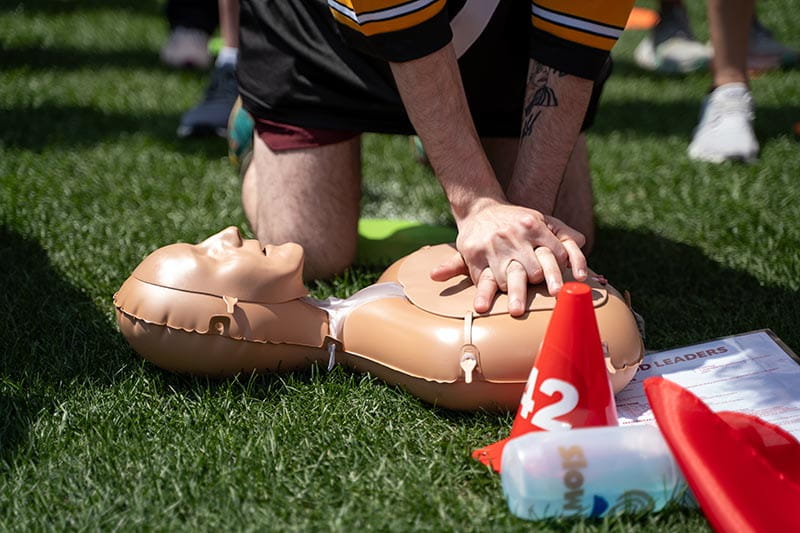 A man performs CPR on a mannequin during a CPR training session.