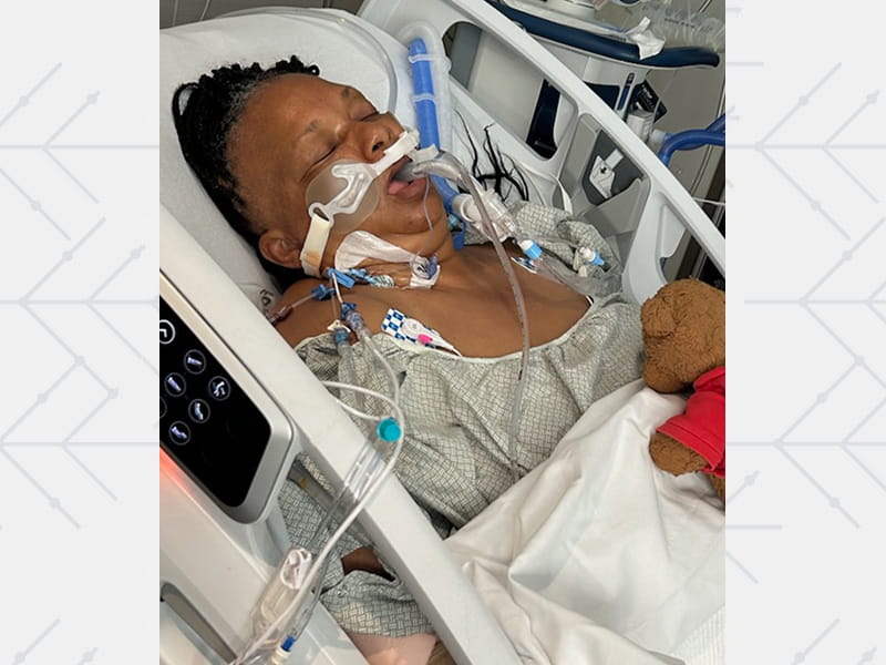 Elizabeth lying in a hospital bed while in a three‑day coma.