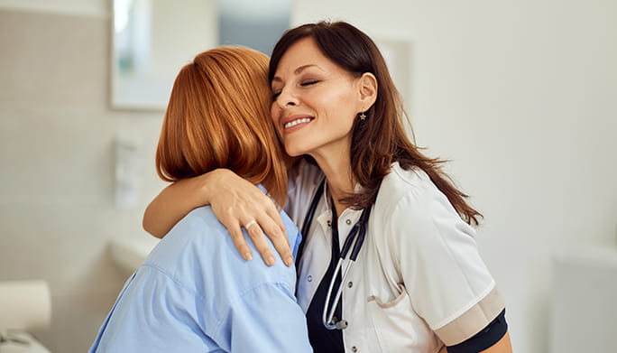 Woman and healthcare professional hugging