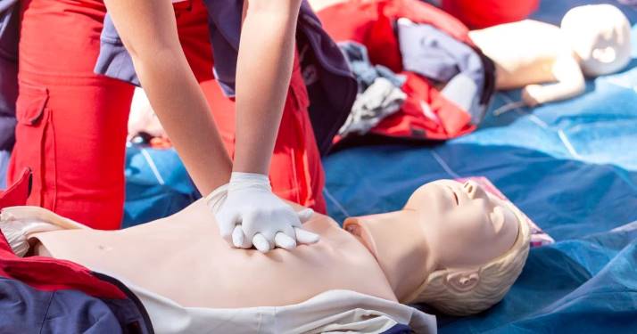 person performing hands only cpr on cpr mannequin