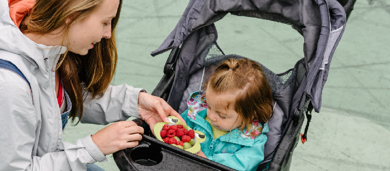 woman feeding baby fruit