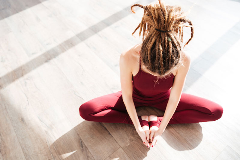 flexible woman with dreadlocks sitting