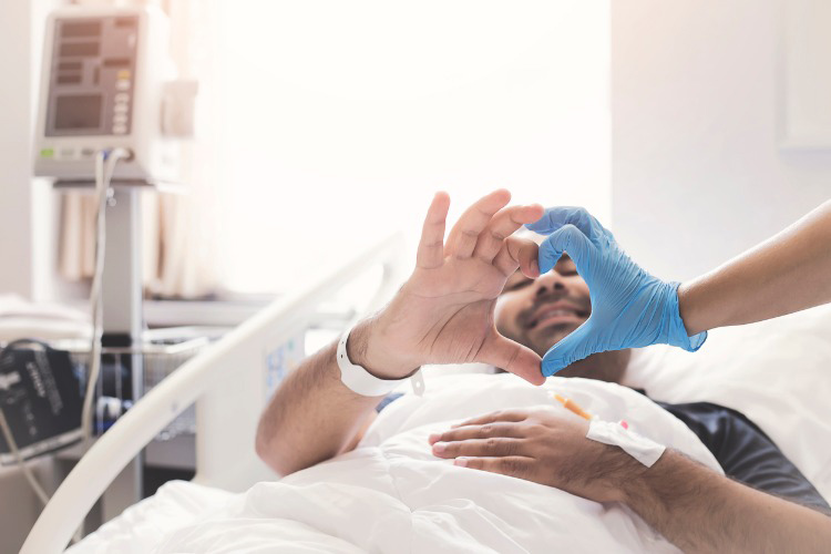 Male patient making a heart shape with doctor